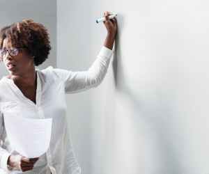 woman in white dress shirt holding blue permanent marker